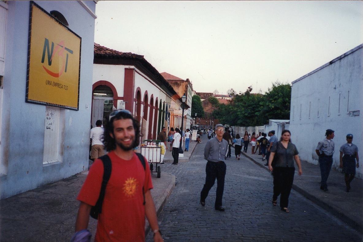 a smiling man on a cobbled colonial street at dusk