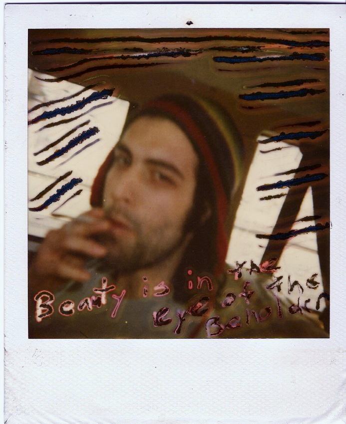 a Polaroid of a bearded man smoking, hand-painted with stripes and text