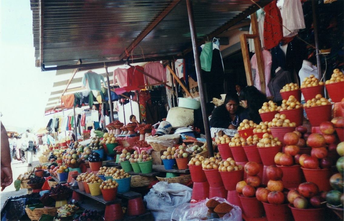 a market stall with fruit stacked in pyramids