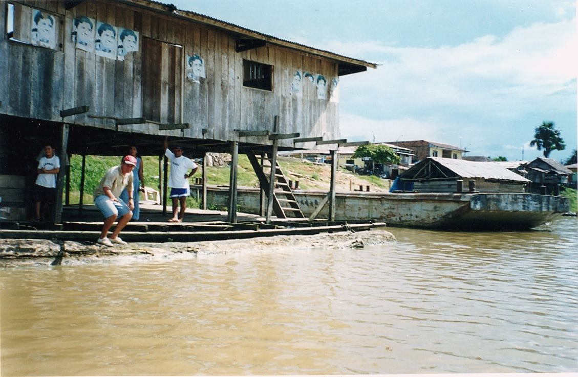 a plank building on posts above the river