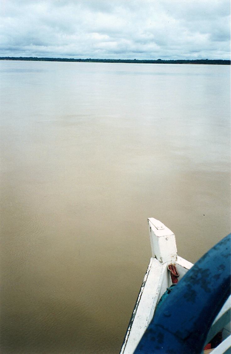 the bow of a boat on flat brown river water