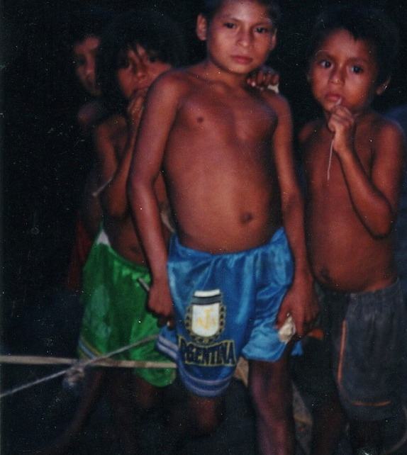 four children outdoors at night, one in Argentina shorts