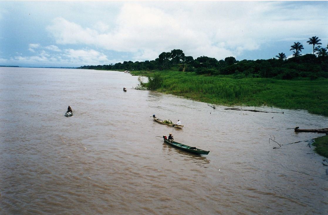 three canoes paddled along a wide brown river