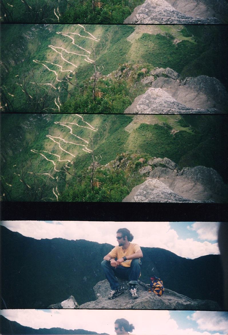 a zigzag road on a slope, a man on a rock