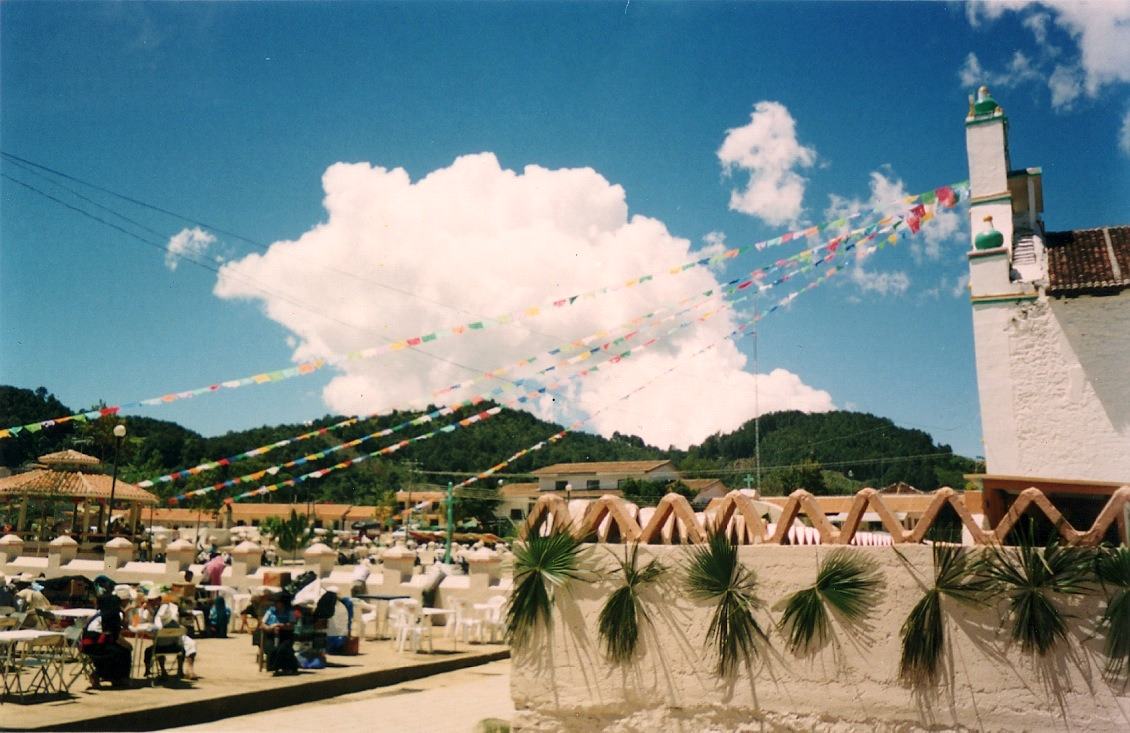 a plaza strung with paper flags, palm fronds on the church