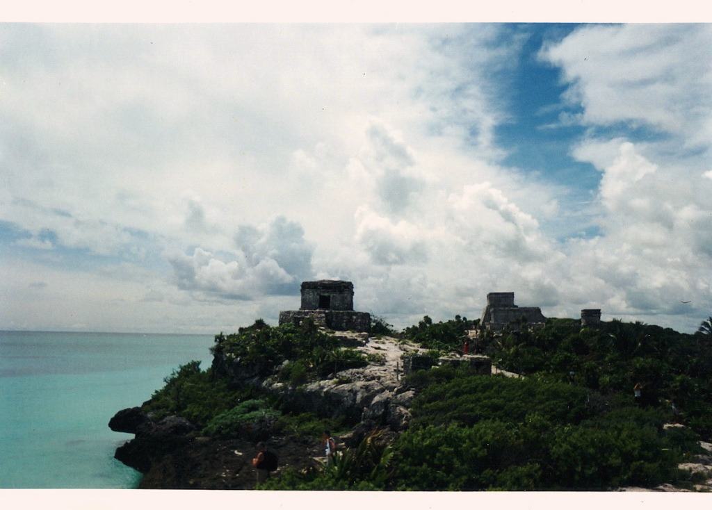 Mayan temples on a headland above turquoise sea